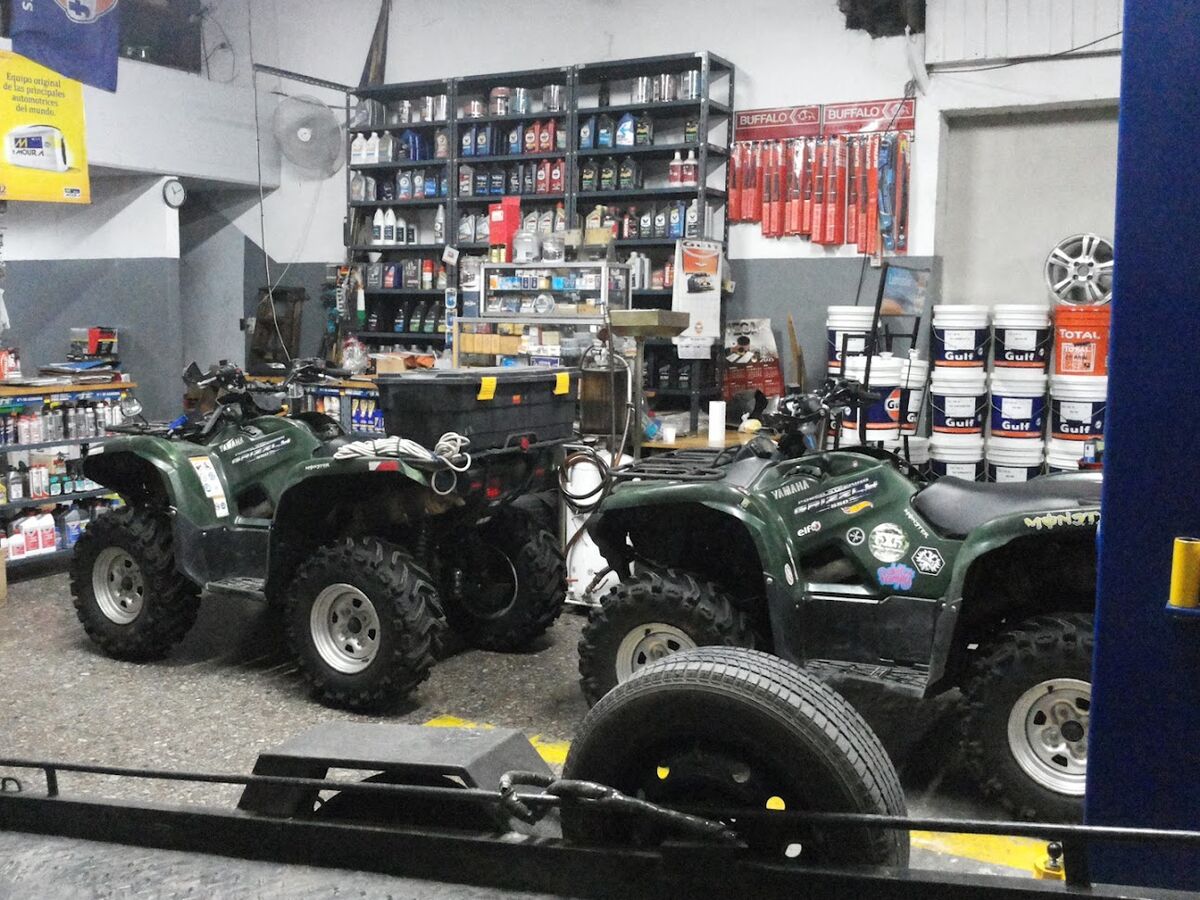 Dos cuatriciclos Yamaha Grizzly estacionados dentro del local, listos para su mantenimiento