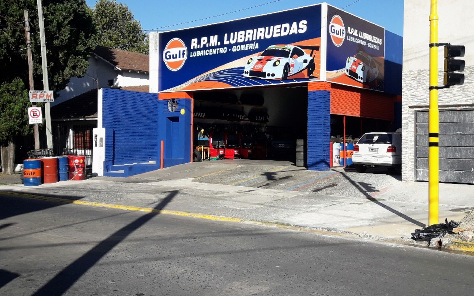 Frente de RPM Lubriruedas sobre Av. Hipólito Yrigoyen en Adrogué, con el cartel Gulf y la entrada al taller